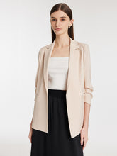 A lady wears an oversized blazer and a skirt.